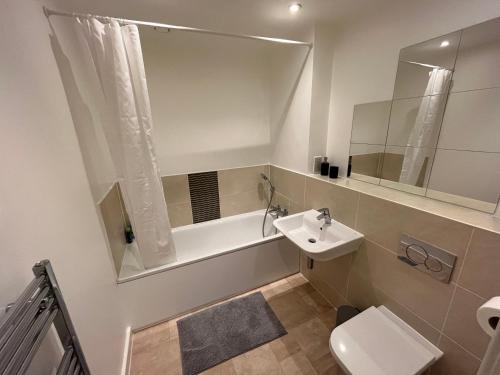 a bathroom with a sink and a toilet and a tub at 2 Bedroom, 2 Bathroom Modern Apartment close to Ocean Village, Free parking, Single or Double beds in Southampton