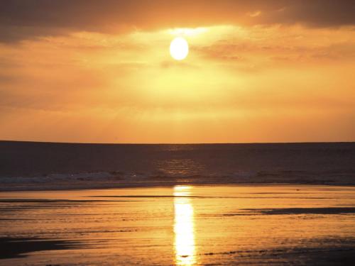 a sunset on the beach with the sun in the sky at d'primahotel Seminyak in Seminyak