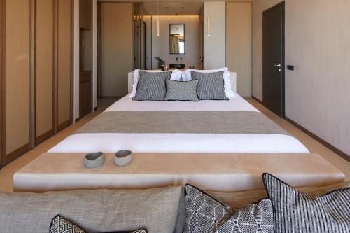 a bedroom with a large bed with two slippers on it at North Santorini - A Luxury Spa Hotel in Pirgos