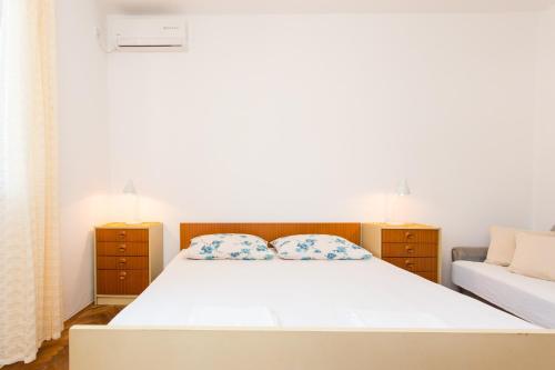 Un dormitorio con una cama blanca y un sofá. en Guest House Ljubica, en Dubrovnik
