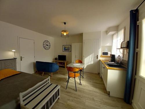 Una habitación con una cama y una cocina con una mesa. en Gîte "Chez Albert et Cie"- 8 mn du Puy du Fou, en Les Herbiers