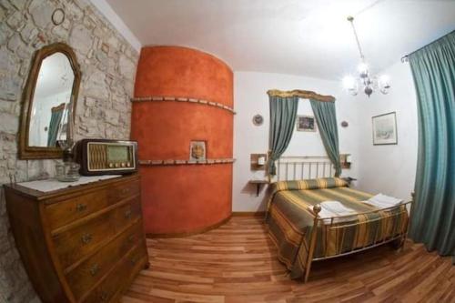 1 dormitorio con 1 cama, vestidor y TV en Le Perine, en Valdobbiadene