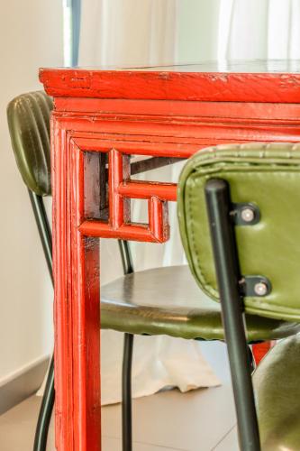 a green chair sitting under a red table at Gazzi Apartments 'Panoramic & Relaxing' in Arco