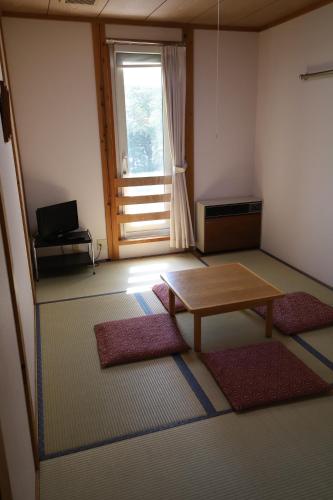 a living room with a table and a window at Lakeside Hotels Kuore in Kitashiobara