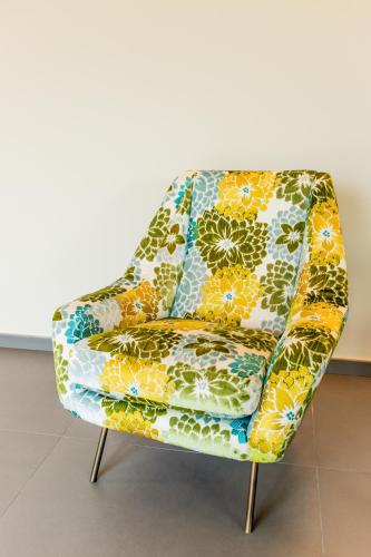a green and yellow chair sitting in a room at Gazzi Apartments 'Panoramic & Relaxing' in Arco