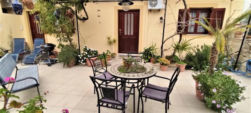 a patio with a table and chairs and plants at House Klimataria Kamilari in Kamilari