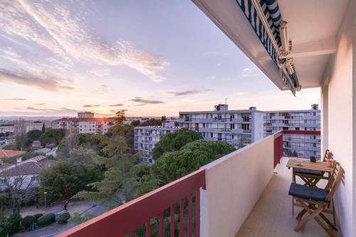 un balcon avec vue sur une ville dans l'établissement Appartement 2 chambres, dernier étage, parking gratuit dans résidence, balcon & coucher de soleil, à Montpellier