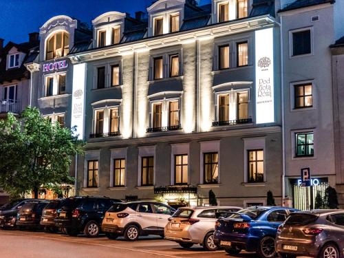 a large building with cars parked in front of it at Hotel Pod Złotą Różą in Kielce