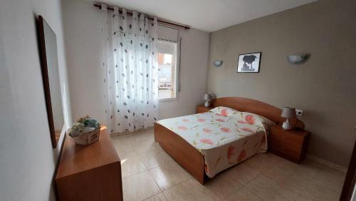 a small bedroom with a bed and a window at Mar i Angels Apartament in Pineda de Mar