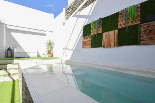 a swimming pool in a house with a white wall at HELOHOME in Huétor Vega