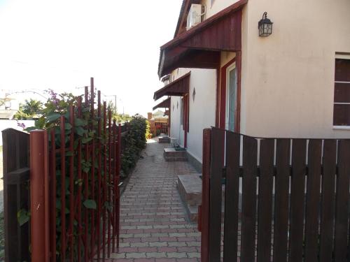 a fence with a brick path next to a building at Casa David in Sulina