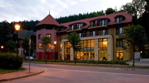 un grande edificio sul lato di una strada di Hotel Habichtstein ad Alexisbad