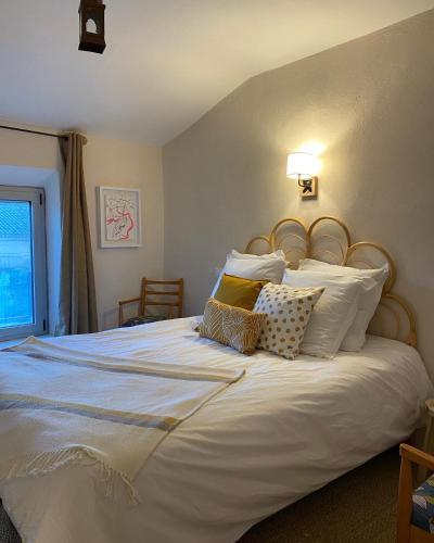 une chambre avec un grand lit blanc avec des oreillers dans l'établissement le Nomade en Provence, à Bouchet