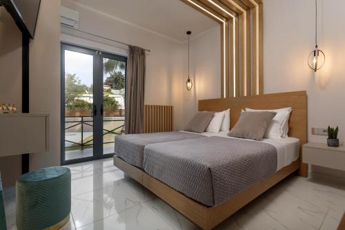 a bedroom with a bed and a large window at Bozikis Villa in Kalpaki