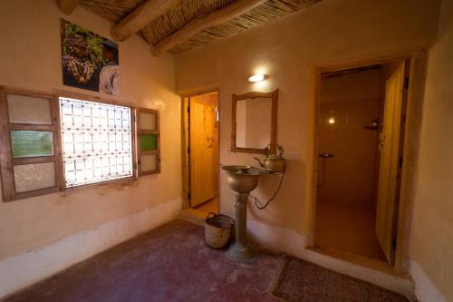 凱拉的住宿－Kasbah Itran，一间带水槽和镜子的浴室以及窗户。