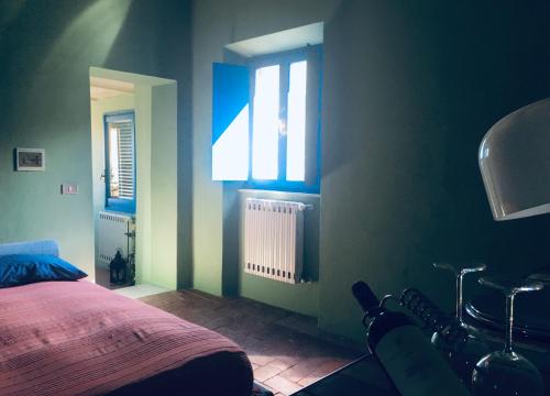 una camera con letto, finestra e sedia di La Casa Rossa degli Artisti a Casciana Terme