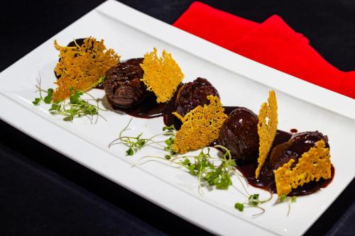 a white plate with chocolate covered desserts on it at Hotel Chicamocha in Bucaramanga