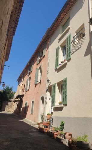 a building with green shutters and potted plants on it at 4 safraniers in Sillans-la Cascade