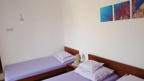 two beds sitting next to each other in a room at Rooms Milena in Lopud Island