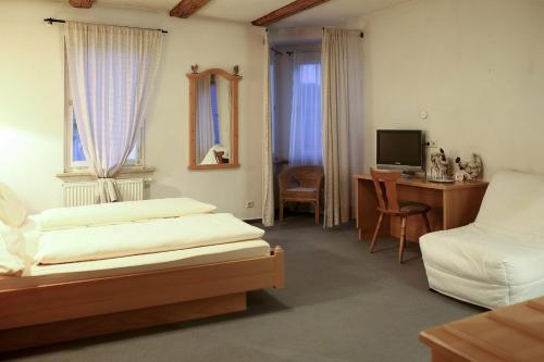 a bedroom with two beds and a desk and a television at Brauereigasthof Hotel Schlüssel in Giengen an der Brenz