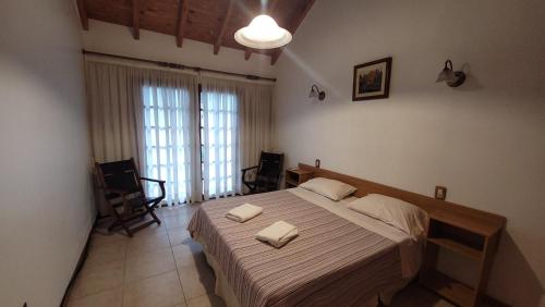 1 dormitorio con 1 cama grande y 2 toallas. en Casa Mendoza Capital cerca del Parque y Centro en La Cieneguita