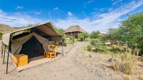 ein Zelt mit einem Stuhl in der Mitte eines Feldes in der Unterkunft Africa Safari Lake Natron Camping in Mtowabaga