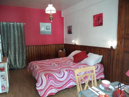 - une chambre dotée d'un lit avec un mur rose dans l'établissement Les Clés du Parc, à Combrand