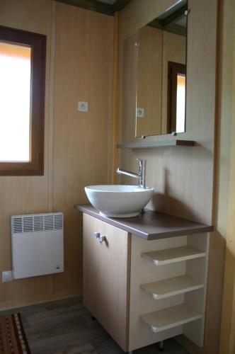 une salle de bain avec un lavabo et un miroir dans l'établissement Chalets du Lac, à Arcizans-Avant