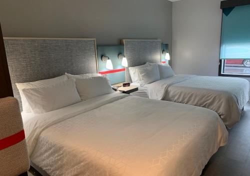 a hotel room with two beds and a window at avid hotels - Salem, an IHG Hotel in Salem