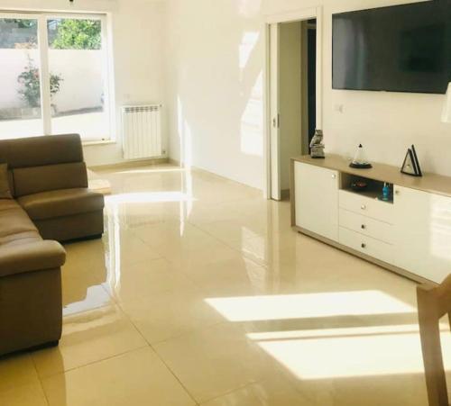 a living room with a couch and a flat screen tv at Villa“La Salentina” in Castrignano del Capo