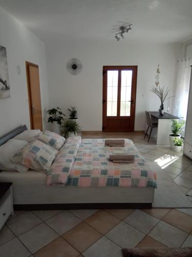 a bedroom with a bed and a table and a window at Studio apartman KIKA in Otočac