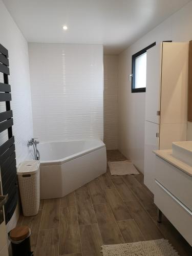 une salle de bain blanche avec une baignoire et un lavabo dans l'établissement Mas Puig Grand Gîte, à Saint-Génis