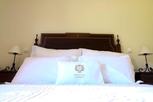 a bedroom with a bed with white pillows at Hotel Rural da Quinta do Silval in Pinhão