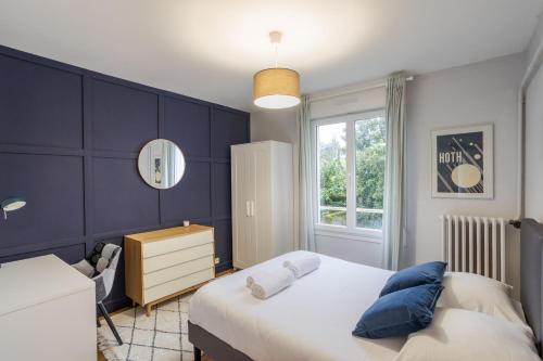une chambre avec un lit aux murs bleus et une fenêtre dans l'établissement LE SÉVIGNÉ - Appartement cocooning à proximité du Thabor, à Rennes