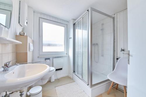 biała łazienka z umywalką i prysznicem w obiekcie Berntraube w mieście Bernkastel-Kues