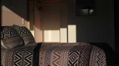 a bed in a room with a blanket on it at B&B Les Lits de Nohaipré in Rendeux