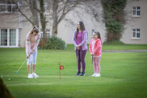 a woman and two girls playing a game of golf at Gleneagle River Apartments in Killarney