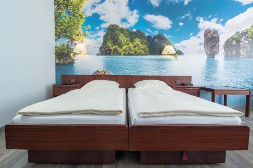 two beds in a room with a view of the ocean at Appart-Hotel-Heldt in Bremen