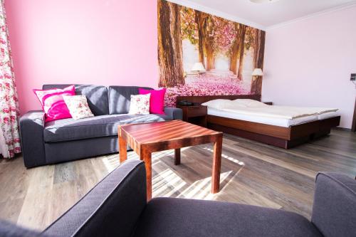 a living room with a couch and a bed at Appart-Hotel-Heldt in Bremen