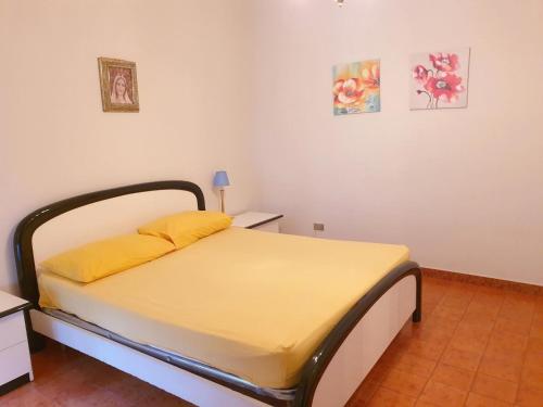 1 cama con sábanas amarillas en una habitación en Residenza armonia, en Gallipoli