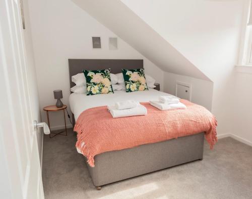 a bedroom with a bed with two towels on it at The Mila - Ayr Racecourse - Coorie Doon Apartments in Ayr