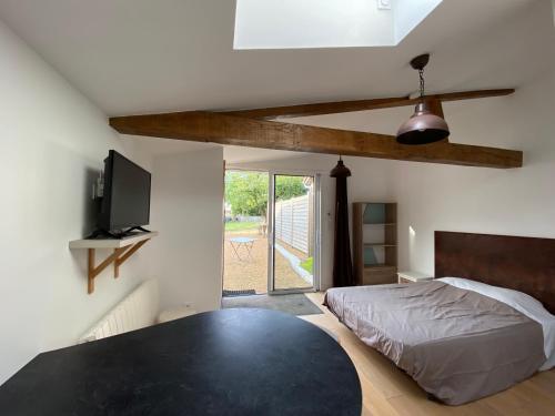 Un dormitorio con una cama y un televisor de pantalla plana. en Gites de la Marniere, en Mouchamps