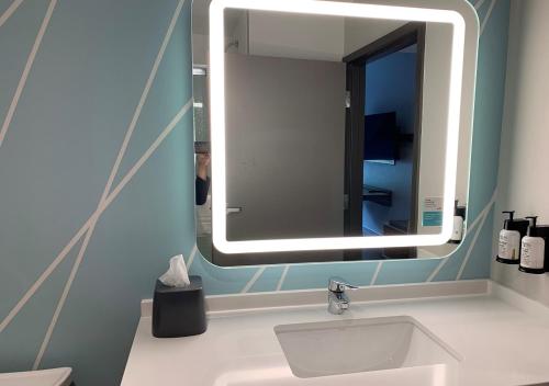 a bathroom with a sink and a mirror at avid hotels - Salem, an IHG Hotel in Salem