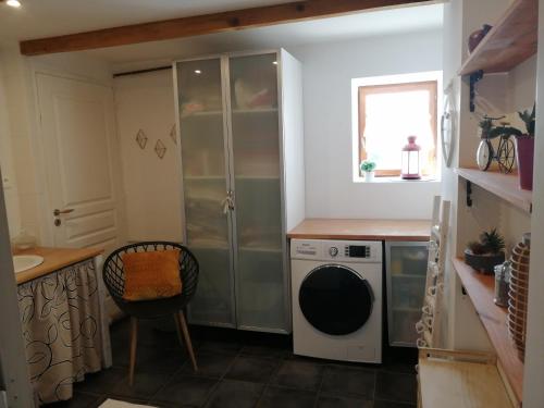a laundry room with a washing machine and a window at Séjour à la campagne in Bouhy