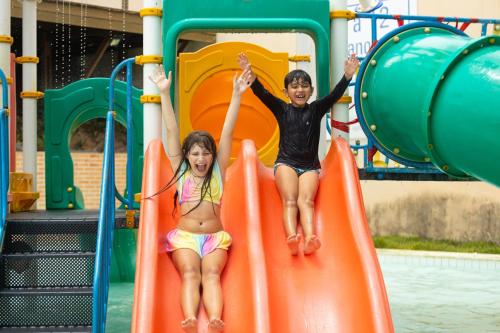 two children playing on a slide at a playground at Praiamar Natal Hotel & Convention in Natal