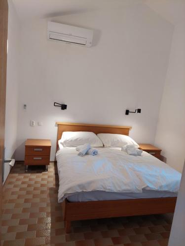 a bedroom with a large bed with white sheets at Gavza Joy in Cres