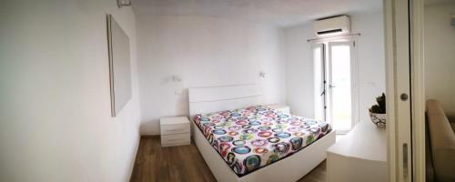a small bedroom with a bed in a white room at La casa dei fichi in Porto Azzurro