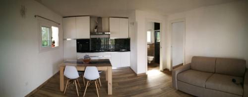 een woonkamer met een bank en een tafel en stoelen bij La casa dei fichi in Porto Azzurro