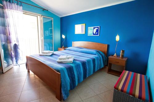 - une chambre bleue avec un lit et des serviettes dans l'établissement Belvedere Sant'Ambrogio, à Cefalù