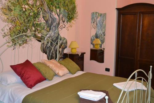 een slaapkamer met een bed met een muurschildering van bomen aan de muur bij B & B Paradise in Melendugno